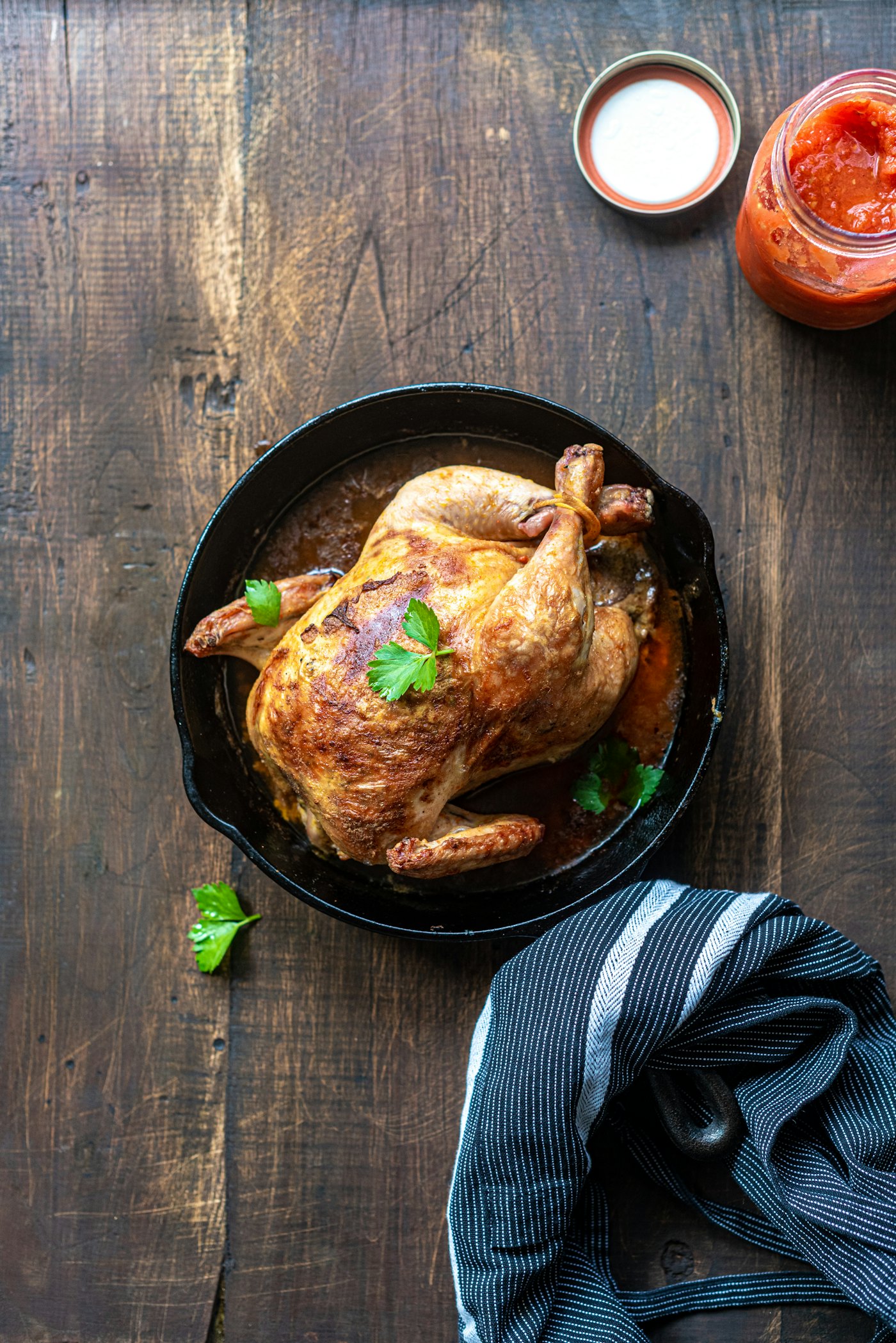 Pollo asado entero, dorado, en sartén de hierro